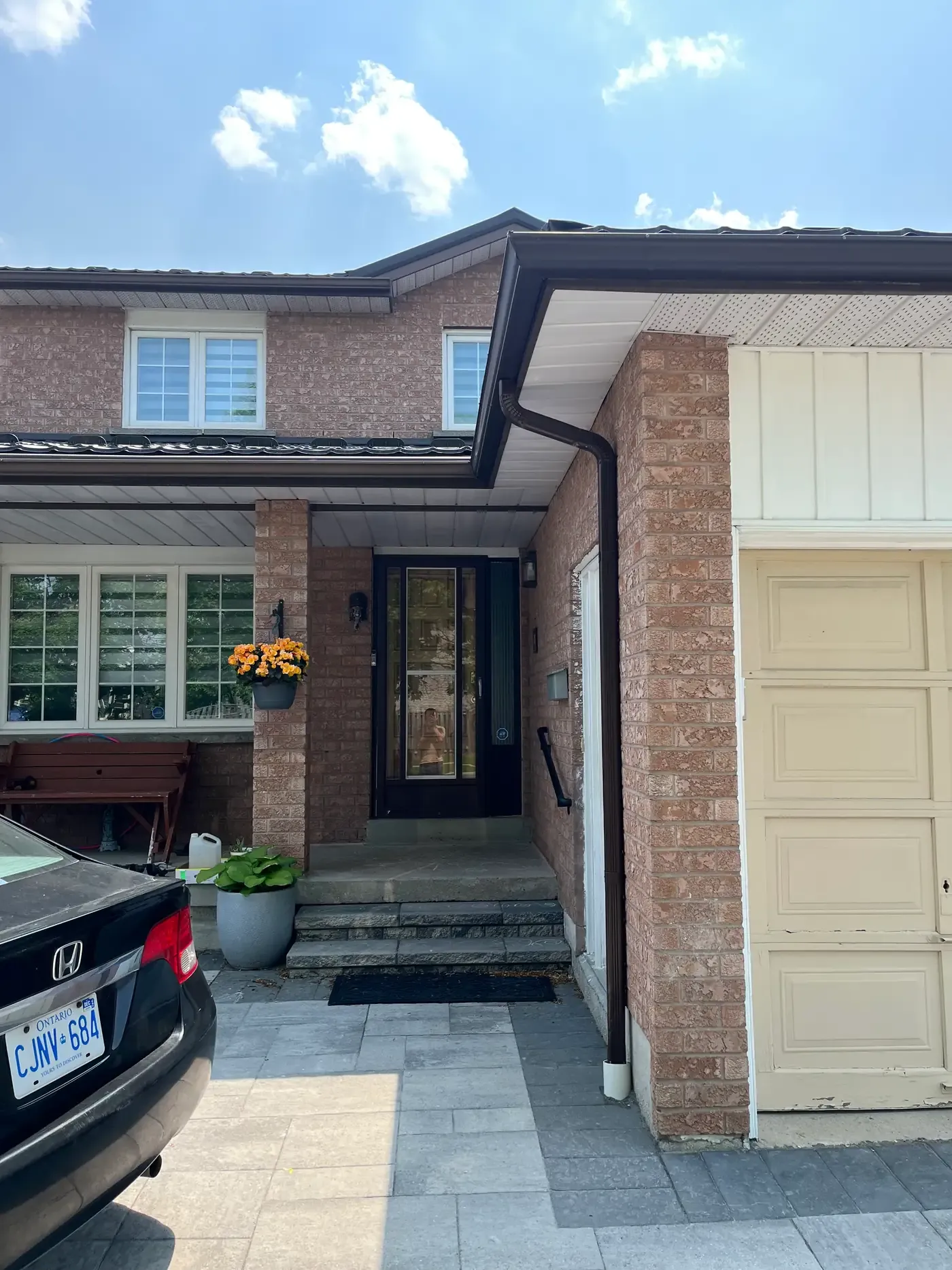 Brick Aurora home with storm door and main entry door under a covered porch
